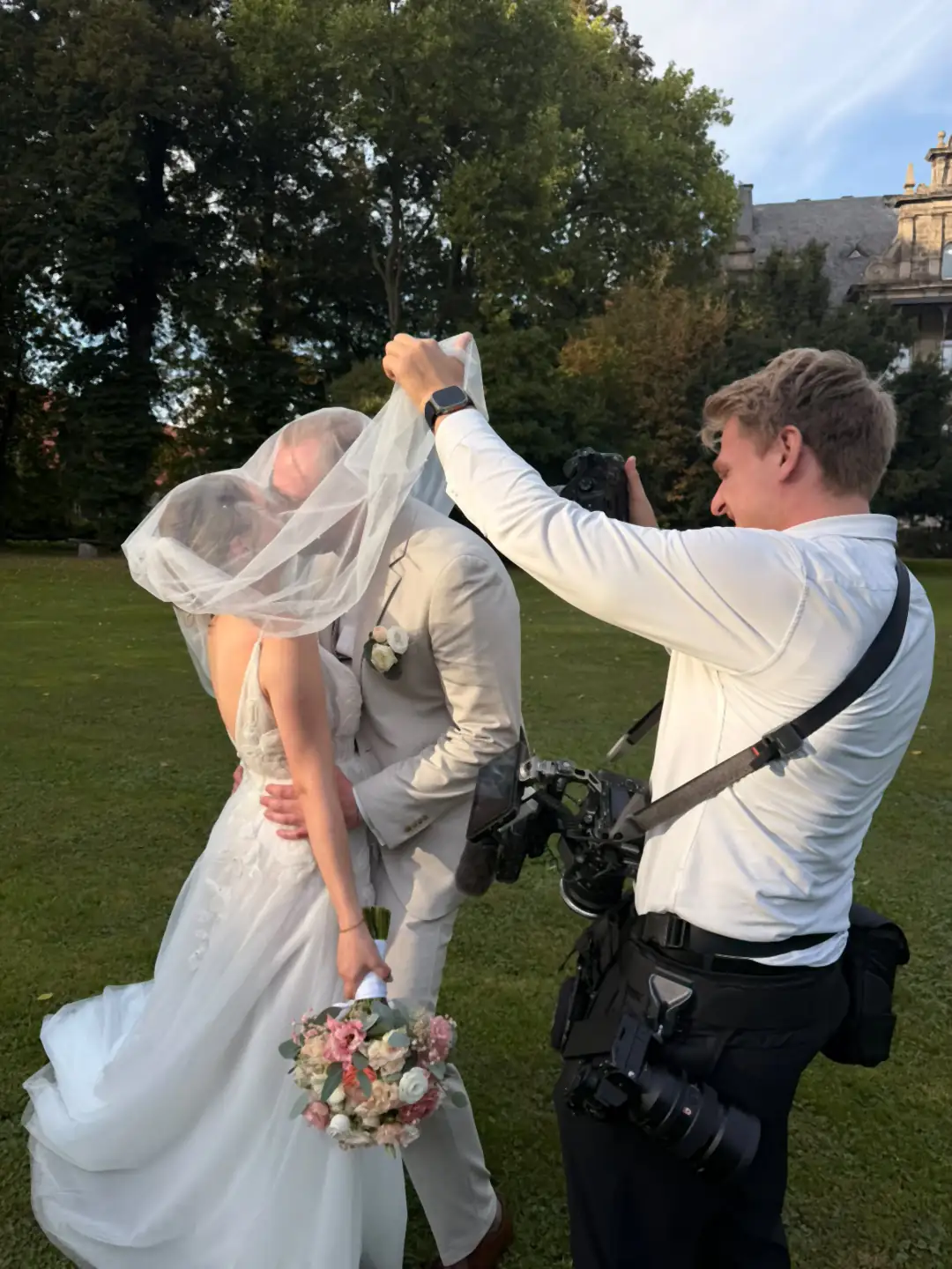 Alex Hartwig fotografiert und filmt gleichzeitig ein Brautpaar unter dem Schleier